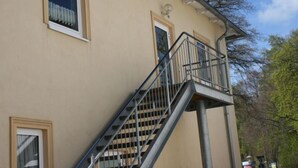 Ein beiges Gebäude mit Balkon und Treppe.