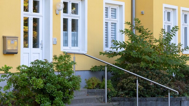 A yellow building with white-framed windows and a metal staircase leading to the entrance. - Apartment Meise by Interhome (Zinnowitz)