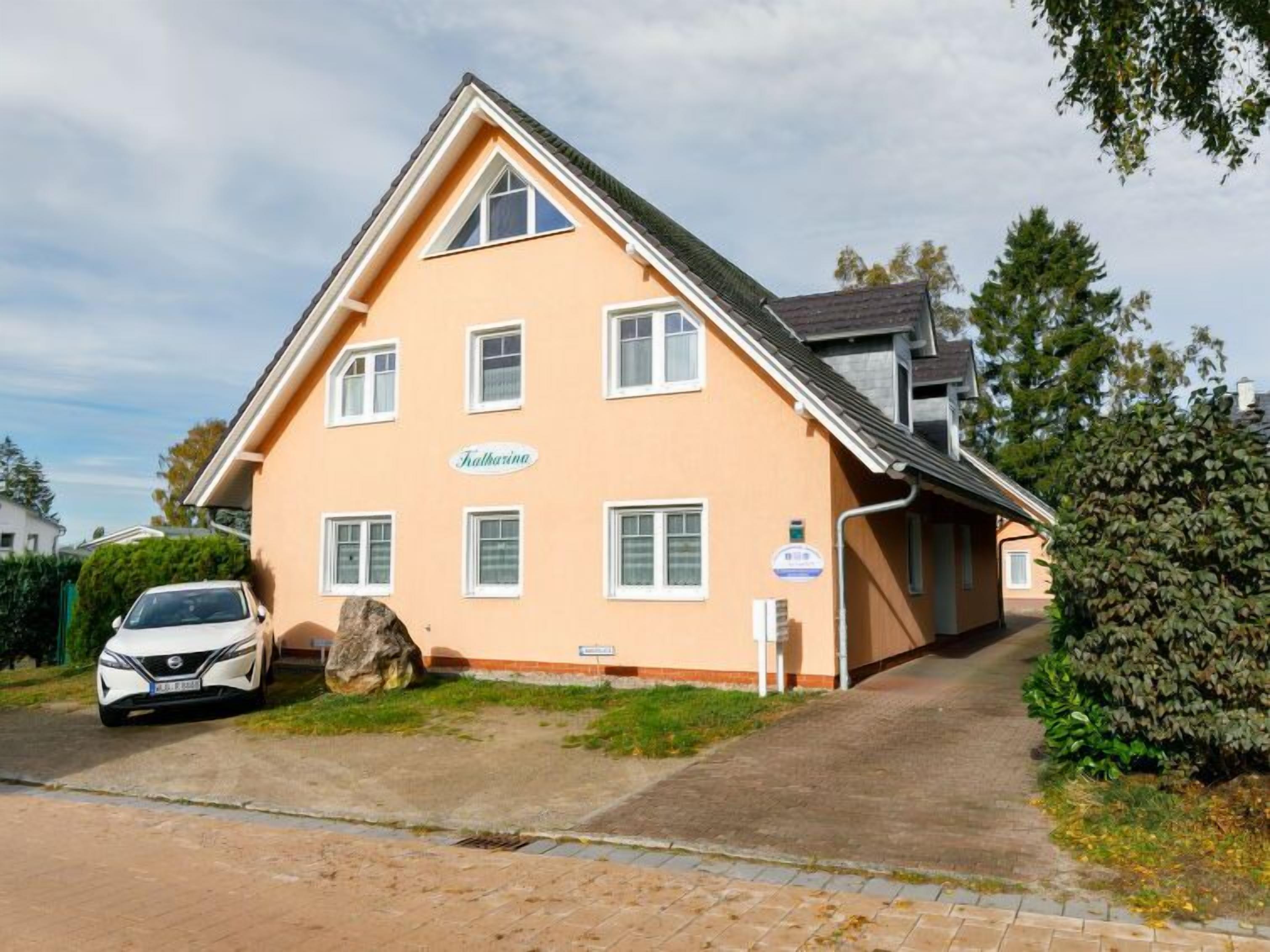 Un bâtiment à deux étages, doté d’une façade de couleur pêche, de nombreuses fenêtres et d’une enseigne sur laquelle on peut lire « Falkarina ».