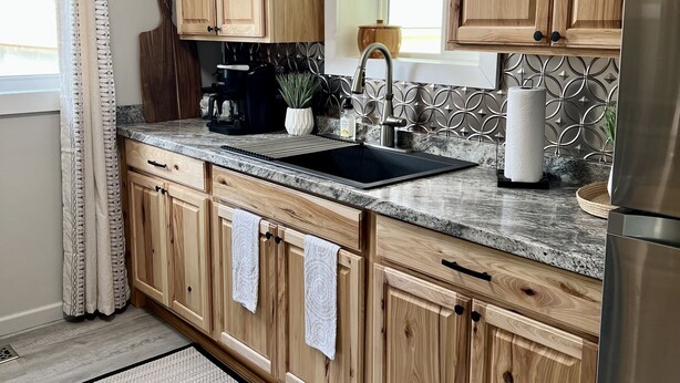 A kitchen with wooden cabinets, a granite countertop, a stainless steel sink, and a refrigerator. - Charming 2 BR home  - newly renovated  (Potsdam)