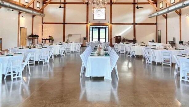 A spacious hall with a high wooden ceiling and a large chandelier. Tables are set up for a formal event. - River District Retreat—Walk to Downtown Belmont! (Belmont)
