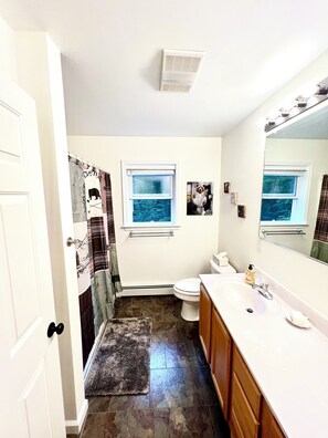 Un baño con inodoro, lavabo y ducha.