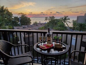 A balcony with a table set for a meal, overlooking a sunset view. - Gorgeous Moon Bay Condo Heated Pool Beach (Key Largo)
