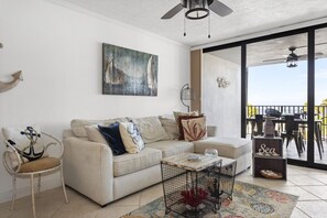 A living room with a sofa, armchair, coffee table, and artwork on the wall. - Gorgeous Moon Bay Condo Heated Pool Beach (Key Largo)