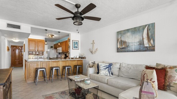 A spacious living area with a kitchen, a dining area, and a sofa with decorative pillows.