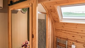 Un interior de madera con un reloj, una ventana y un perchero.