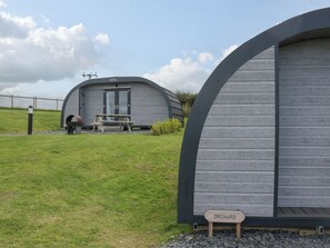 A modern, semi-open structure with a bench and a sign labeled "ORCHARD" in front. - Orchard (Dalton-in-Furness)