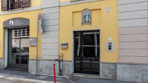 A building with a yellow facade, a black entrance door, and a sign for Daniel Grandolphi Photography. - notaMI - Forcella Fashion District  (Milan)