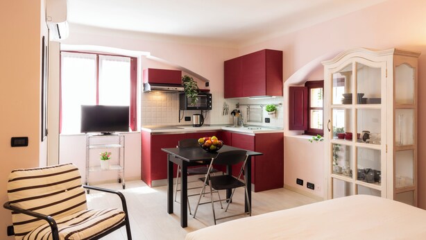 A compact kitchen with a dining area, a TV, and a cabinet with glass doors. - notaMI - Forcella Fashion District  (Milan)
