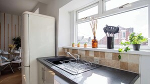 Una cocina moderna con lavavajillas integrado, una ventana con vistas a la ciudad y un comedor con mesa y sillas.