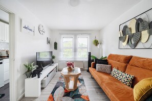 Un salon moderne avec un téléviseur, un canapé et des objets de décoration.