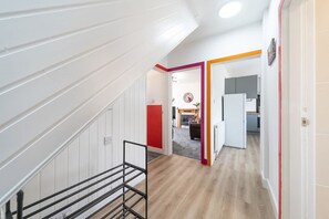 A staircase leading to a living area with a kitchen in the background.