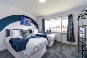 A room with a bed, a window, a radiator, and a black metal rack.