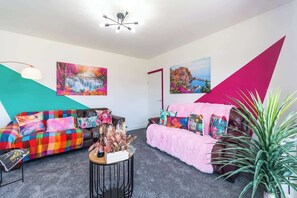 Ein Wohnzimmer mit zwei Sofas, einem Couchtisch und Wandbildern.