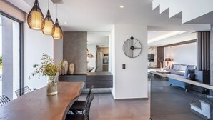 Una cocina moderna con encimera de madera, luces colgantes y vista al área de comedor.