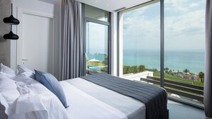 Un dormitorio con un amplio ventanal que ofrece vista al mar y un balcón.