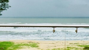 A beach view with a railing and waves. - Raj Sea Front Beach Resort 102 (Mangaluru)