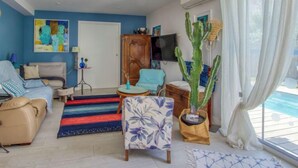 Una sala de estar con un sofá, un sillón y una gran planta de cactus.