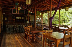 Un interior de madera con una zona de bar, estanterías y una escalera.