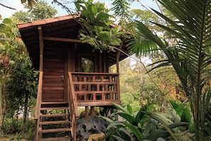 A wooden structure with a balcony, surrounded by lush greenery. - Ritmo Del Rio - Hotel y Restaurante (San Rafael)