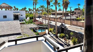 Un quartier résidentiel doté d’une piscine, de palmiers et d’un mur en pierre.