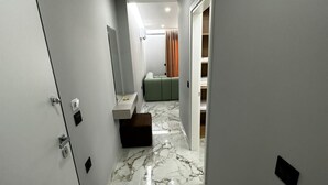A hallway with a marble floor leading to a room with a bed and a bathroom. - Albania Dream Holidays Accommodation (Sarandë)