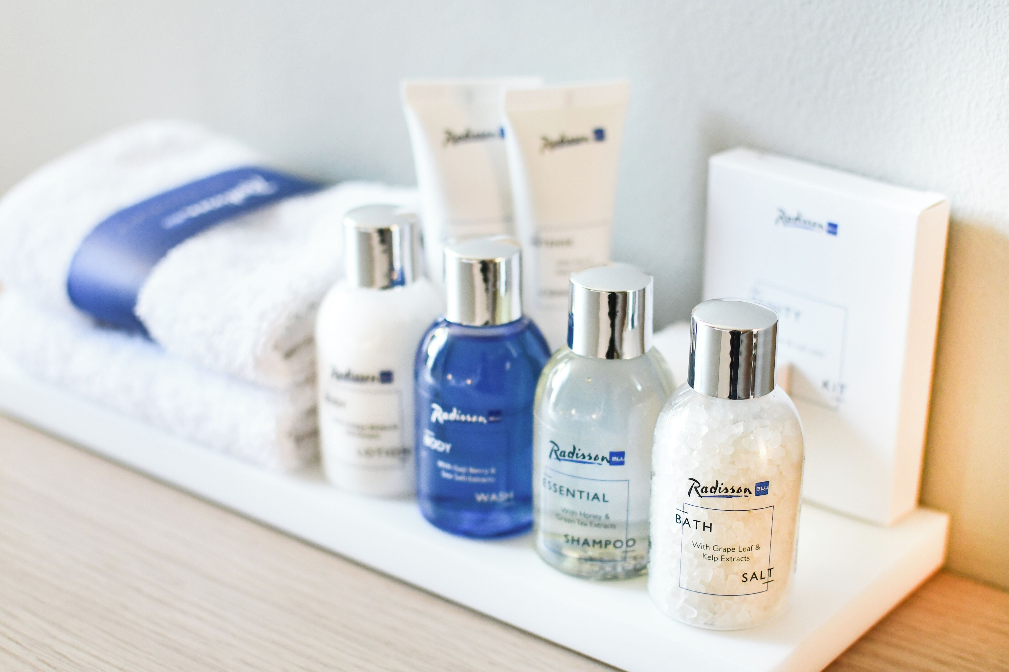 A shelf with various Radisson toiletries including a body wash, shampoo, and salt.