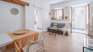 Un vaste espace de vie comprenant une table à manger, un canapé et une grande fenêtre.