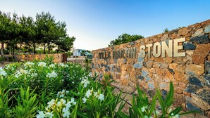 A stone wall with the text "VILLA MARTIN STONE" and surrounding greenery. - Villa Martin Stone Las Colinas Golf Country Club (VC)
