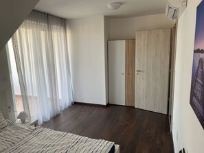 Un dormitorio con cama, un armario de madera y una puerta que da a otra habitación.