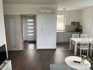 A modern kitchen with a dining area, a built-in air conditioner, and a view of the outdoors. - Vitorlás apartman 1 (Balatonszárszó)