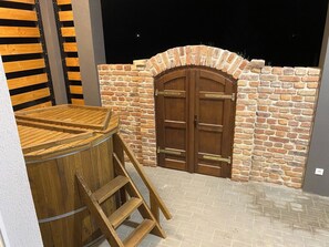 A wooden barrel with a ladder, a wooden door, and a brick wall. - Vitorlás apartman 1 (Balatonszárszó)