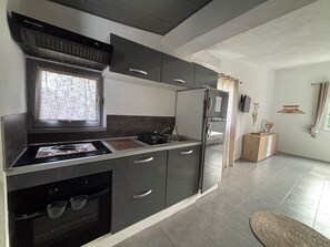 A modern kitchen with a built-in oven, a stovetop, and a refrigerator.
