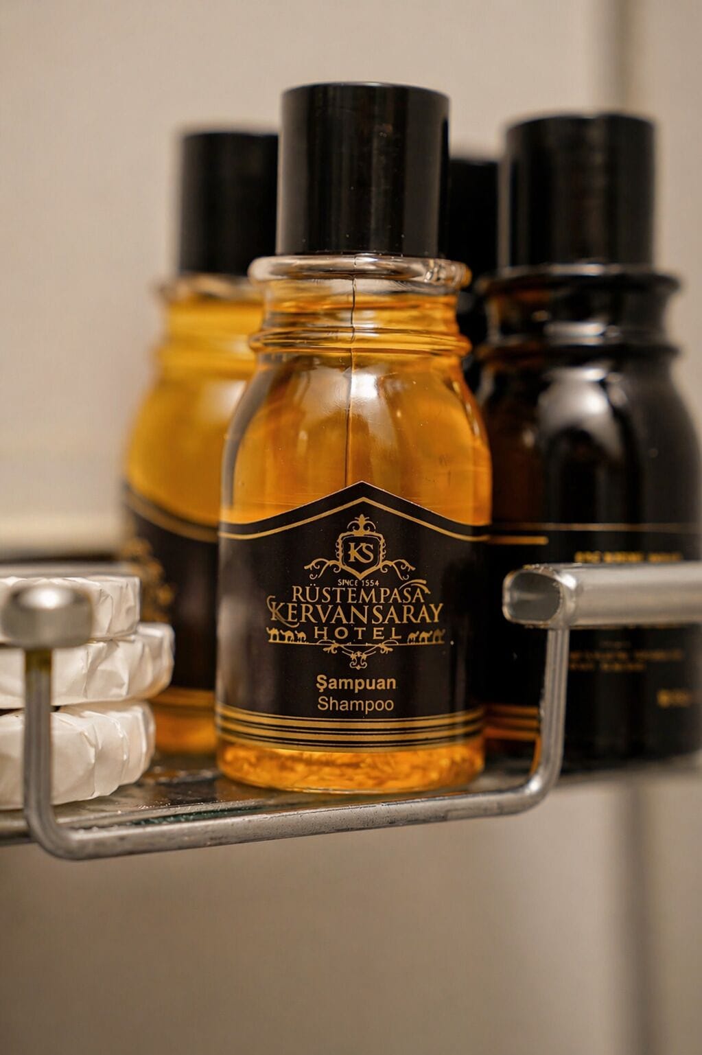 A bottle of shampoo on a shelf with other toiletries.