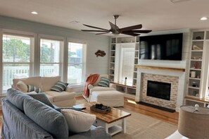 Relax in this inviting living room with a fireplace, flat-screen TV, and comfortable seating.