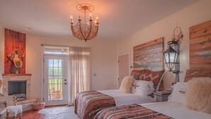 A spacious bedroom with a large bed, a fireplace, and a chandelier. - The Stardust Room - Wander Inn (Round Top)