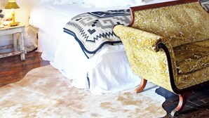 A bedroom with a bed, a vintage chair, a nightstand with a lamp, and a wall sign that reads "COUNTRY DELIGHT". - Country Delight Room - Wander Inn (Round Top)