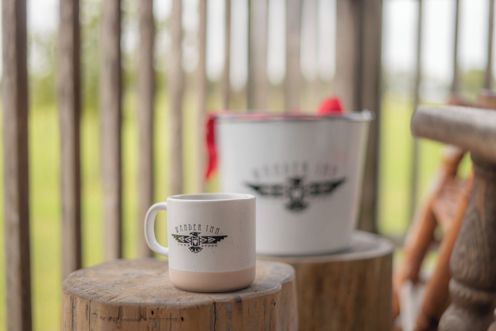 A white mug with a logo on a wooden stump.