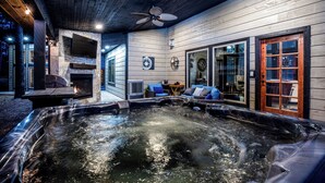 A hot tub area with a ceiling fan, a stone fireplace, and a seating area with a view of the outdoors. - 2Bdr with elevated design and bunkhouse! (Broken Bow)