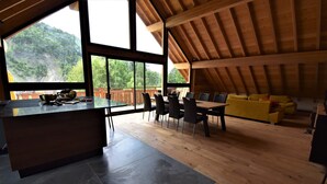 A spacious loft with a dining area, a kitchen, and a yellow sofa. - Chalet Sert et Sagne 1 (Vaujany)