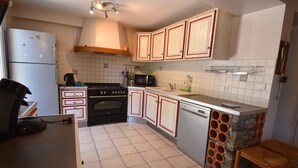 A compact kitchen with a refrigerator, stove, microwave, and sink. - Chalet Roches Grandes 47 (Vaujany)