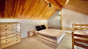 A bedroom with a sloped ceiling, a bed, a dresser, and a desk. - Appartement de La Fare, Apt 30 (Vaujany)