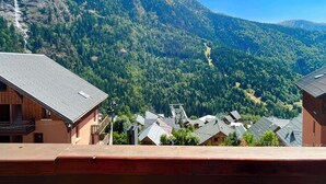 A mountain village with traditional wooden houses, a clear sky, and a valley below. - Appartement de La Fare, Apt 30 (Vaujany)