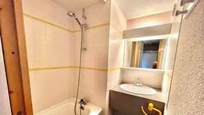 A compact bathroom with a bathtub, a sink, and a mirror. - Appartement de La Fare, Apt 30 (Vaujany)