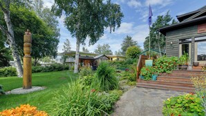 A residential property with a well-maintained garden, a wooden deck, and a pathway leading to the entrance.
