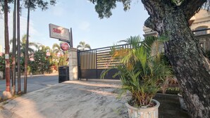 A gated entrance with a signboard, a potted plant, and a tree. - OYO 90359 Sbh Residence (Medan)