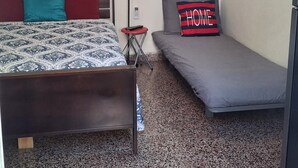 A bedroom with a bed, a sofa, and two paintings. - Stay as a tourist & feel as a local; Beach & Loiza st. strip, everything near! (San Juan)