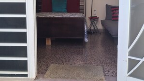 A room with a bed, a ceiling fan, and artwork on the walls. - Stay as a tourist & feel as a local; Beach & Loiza st. strip, everything near! (San Juan)