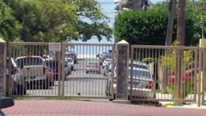 A gated parking area with multiple cars parked. - Stay as a tourist & feel as a local; Beach & Loiza st. strip, everything near! (San Juan)