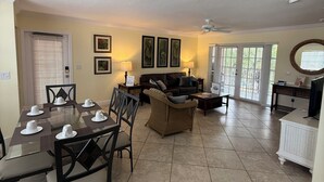 A spacious living room with a dining area, a fireplace, and a large window. - Siesta Key Inn (Siesta Key)